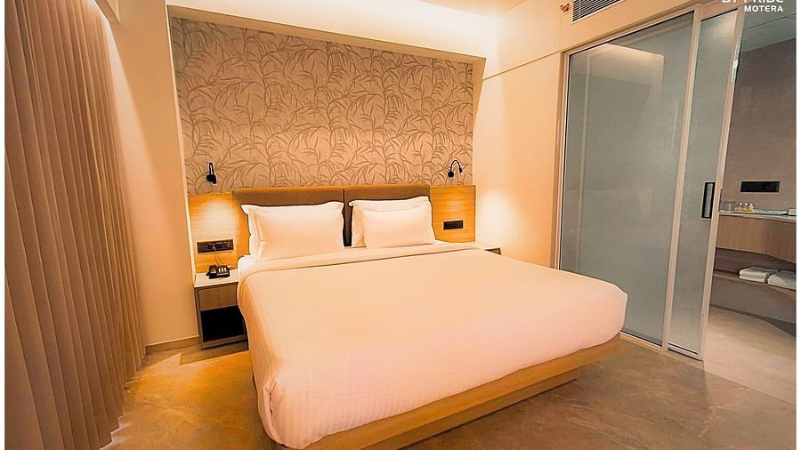 image featureing a plush double bed with bed side tables and a sleek wallpaper - biznotel by pride, motera